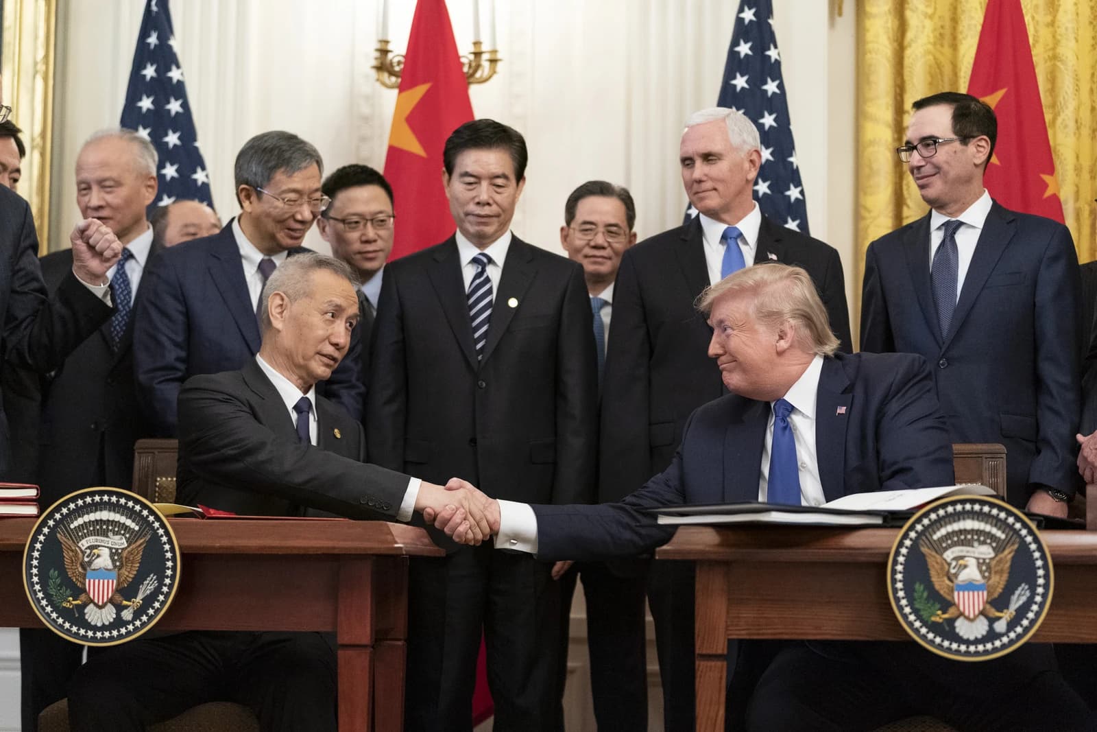 Donald Trump and Chinese Vice Premier Liu He shake hands at a signing ceremony.