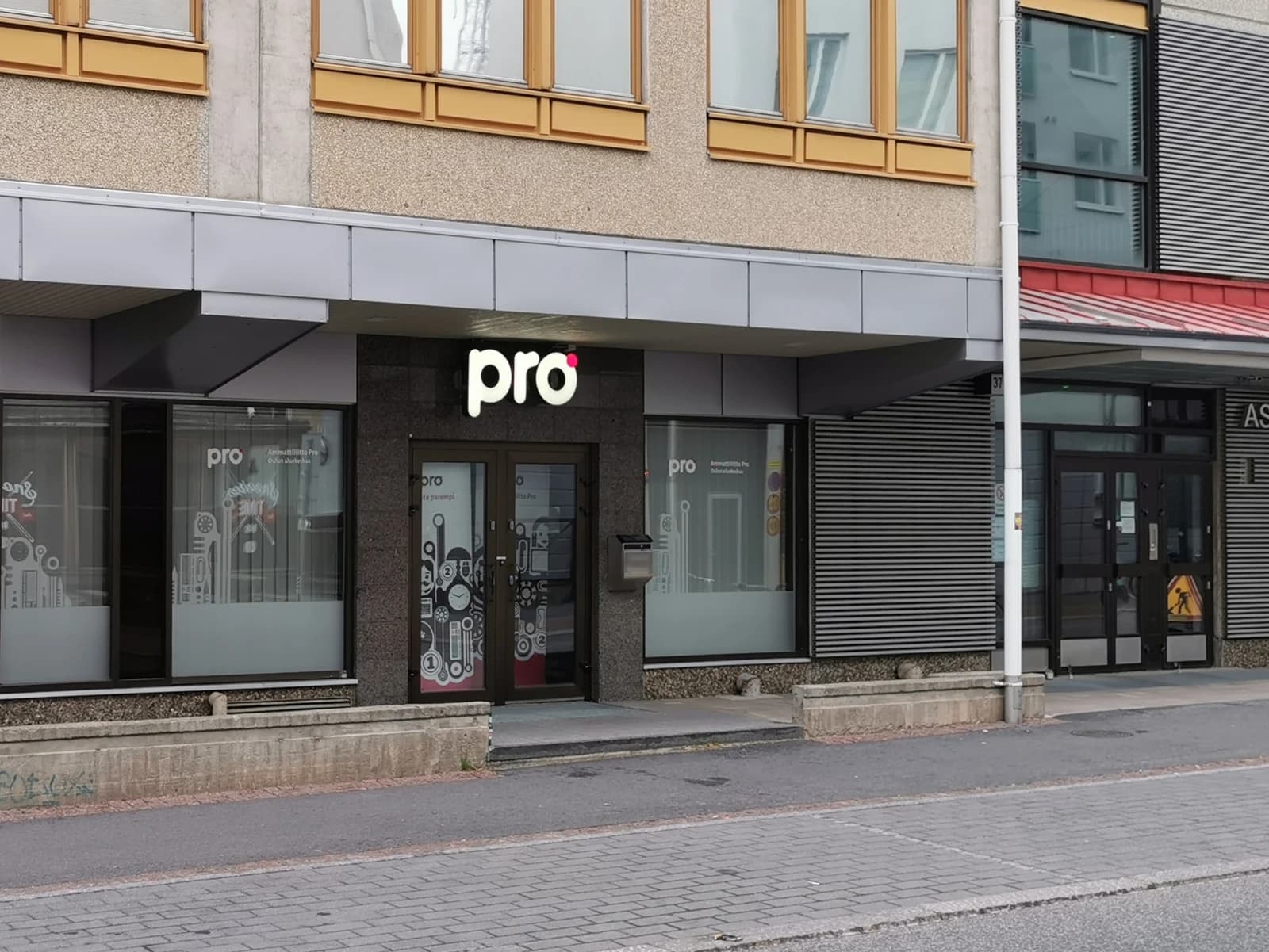 Building facade with the word "pro" lit up above an entrance in Oulu.