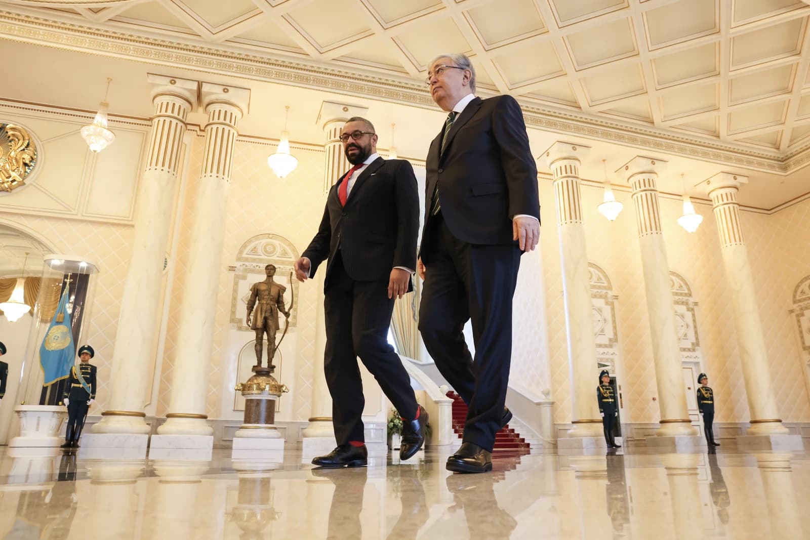 James Cleverly, UK Foreign Secretary, walks with a Kazakh dignitary indoors.