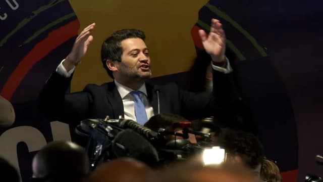 André Ventura, leader of Chega, speaking passionately with raised arms at an event.