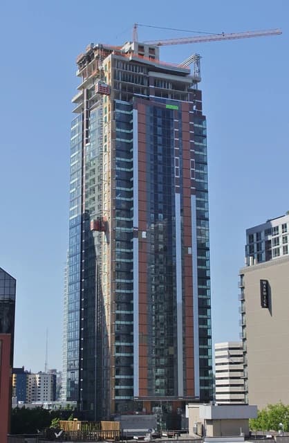 High-rise condominium tower under construction in a city setting.