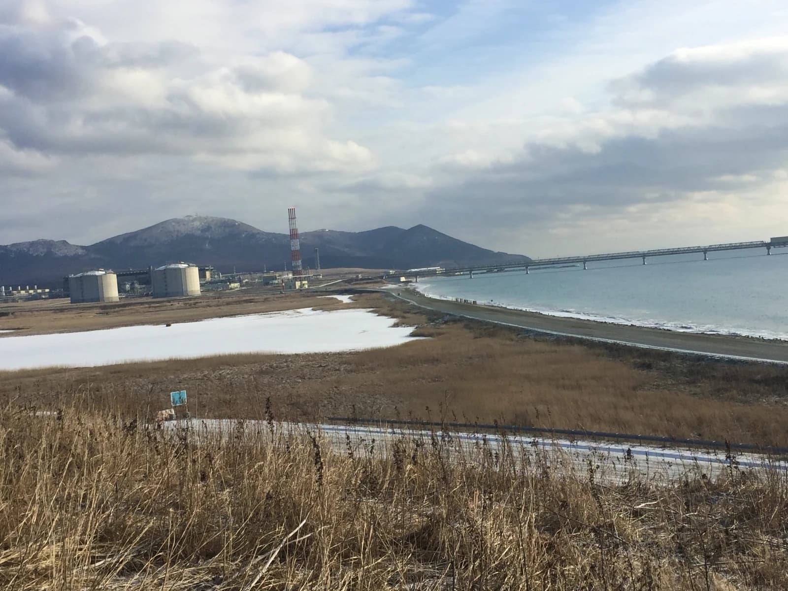 Port Prigorodnoye LNG terminal storage tanks and infrastructure by the sea.