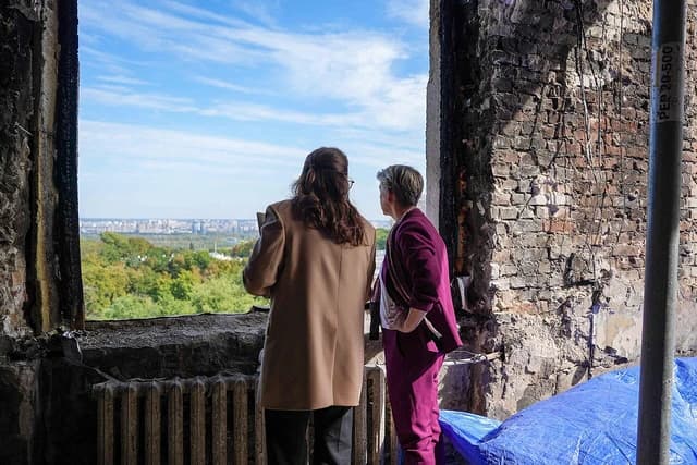 Yvette Cooper, Foreign Secretary, and another person stand looking out over Kyiv, Ukraine.