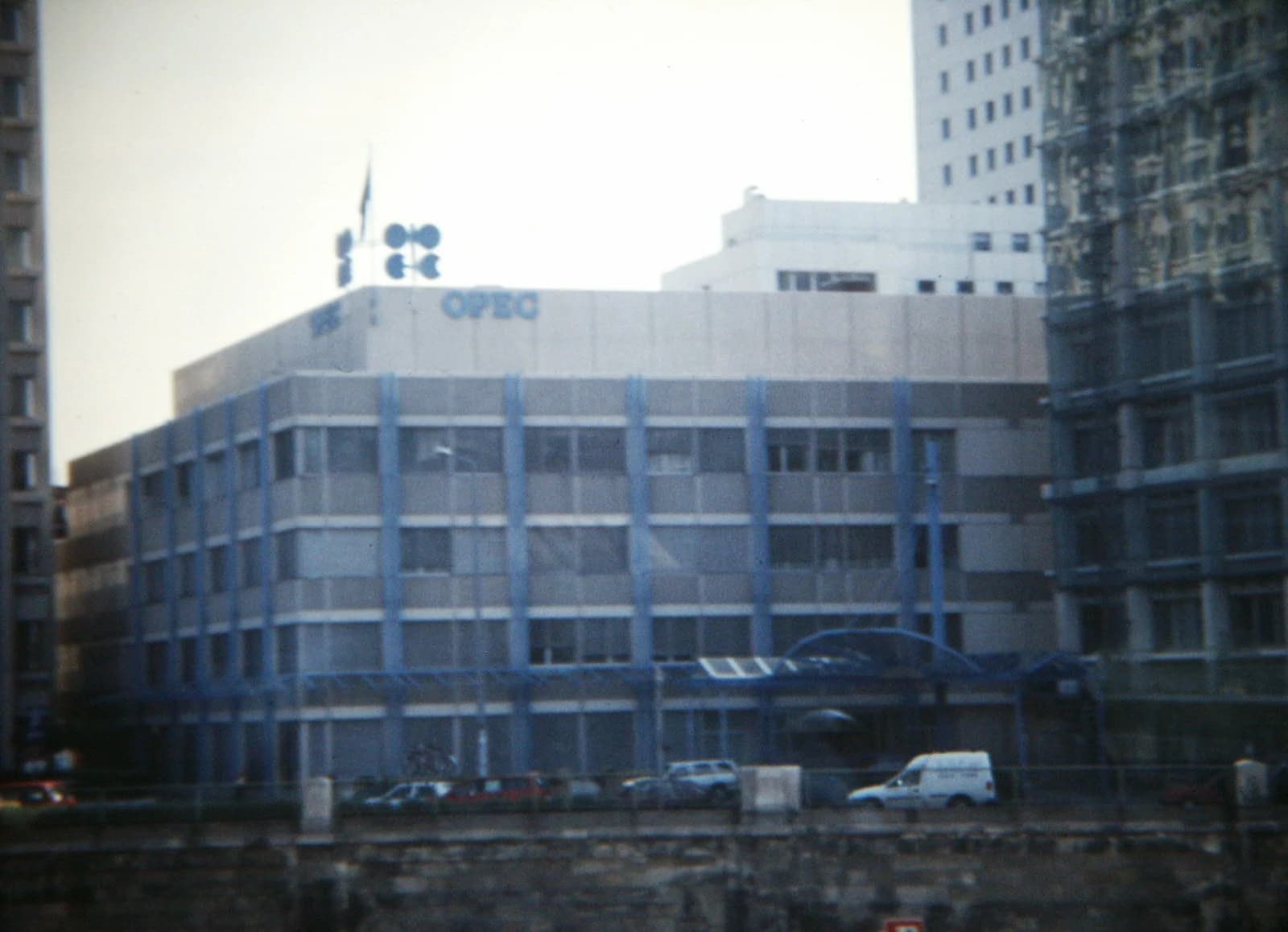 Exterior view of the OPEC Headquarters building in Vienna, Austria, with cars parked outside.