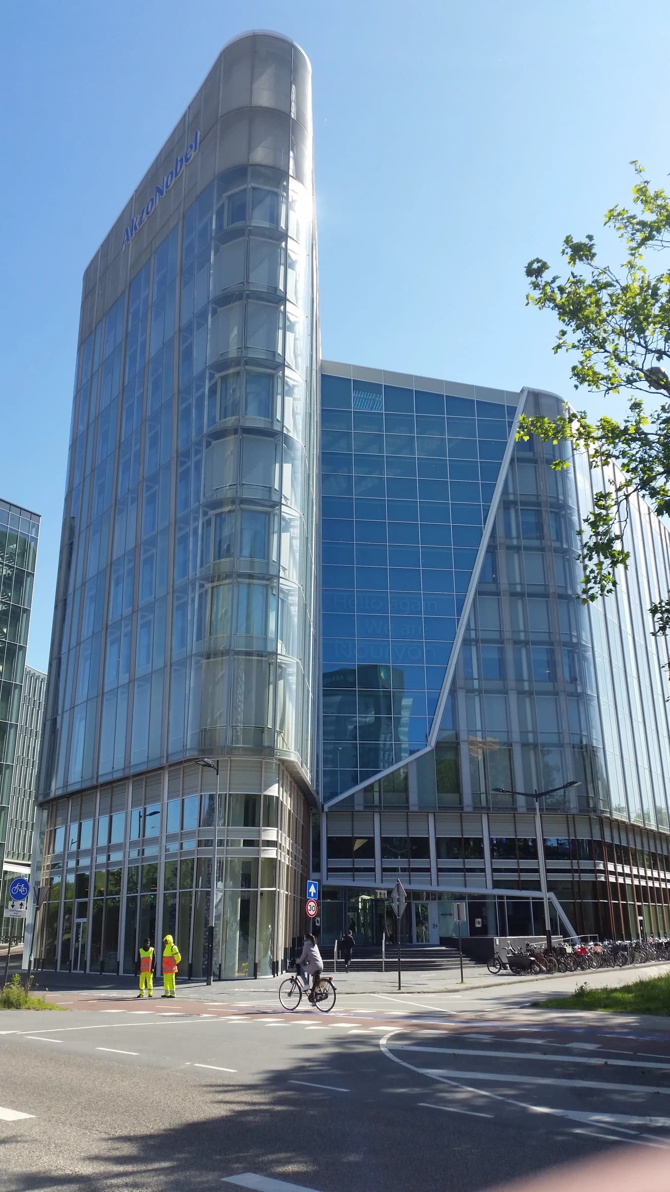 AkzoNobel headquarters building, a modern glass skyscraper, on a sunny day.