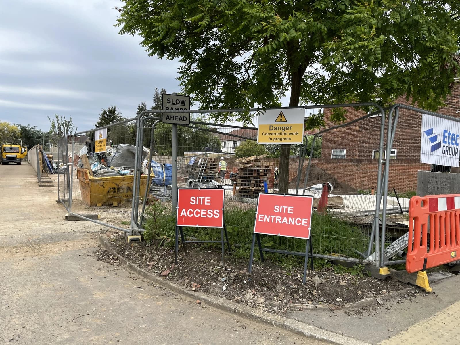 Building site with entrance and access signage visible on the foreground.
