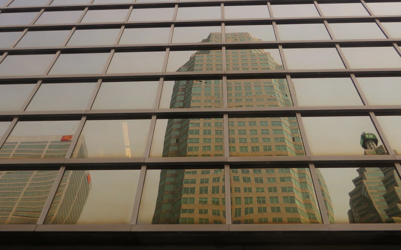 Reflections of modern skyscrapers on the glass facade of an adjacent building.