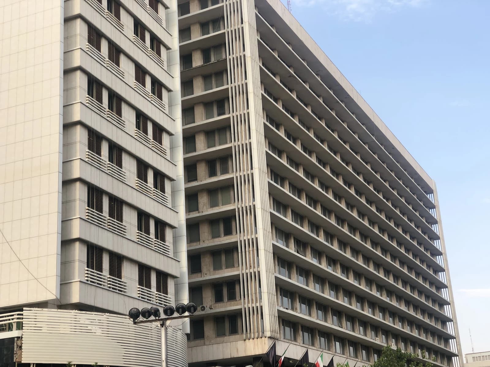 Modern building with many windows and some national flags visible at the base.