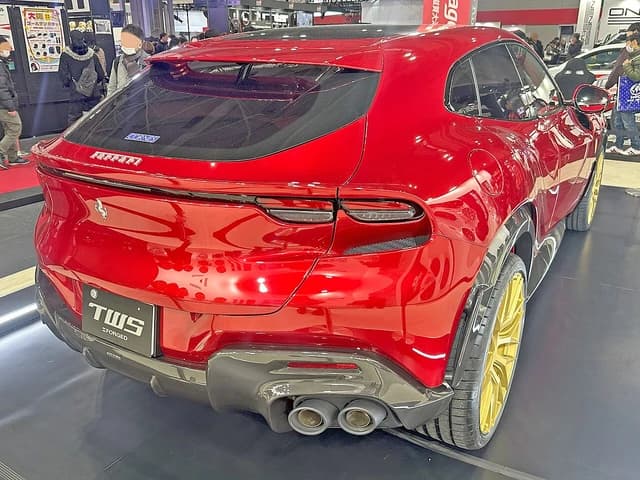 Red Ferrari Purosangue with gold TWS wheels on display at the Osaka Auto Messe.