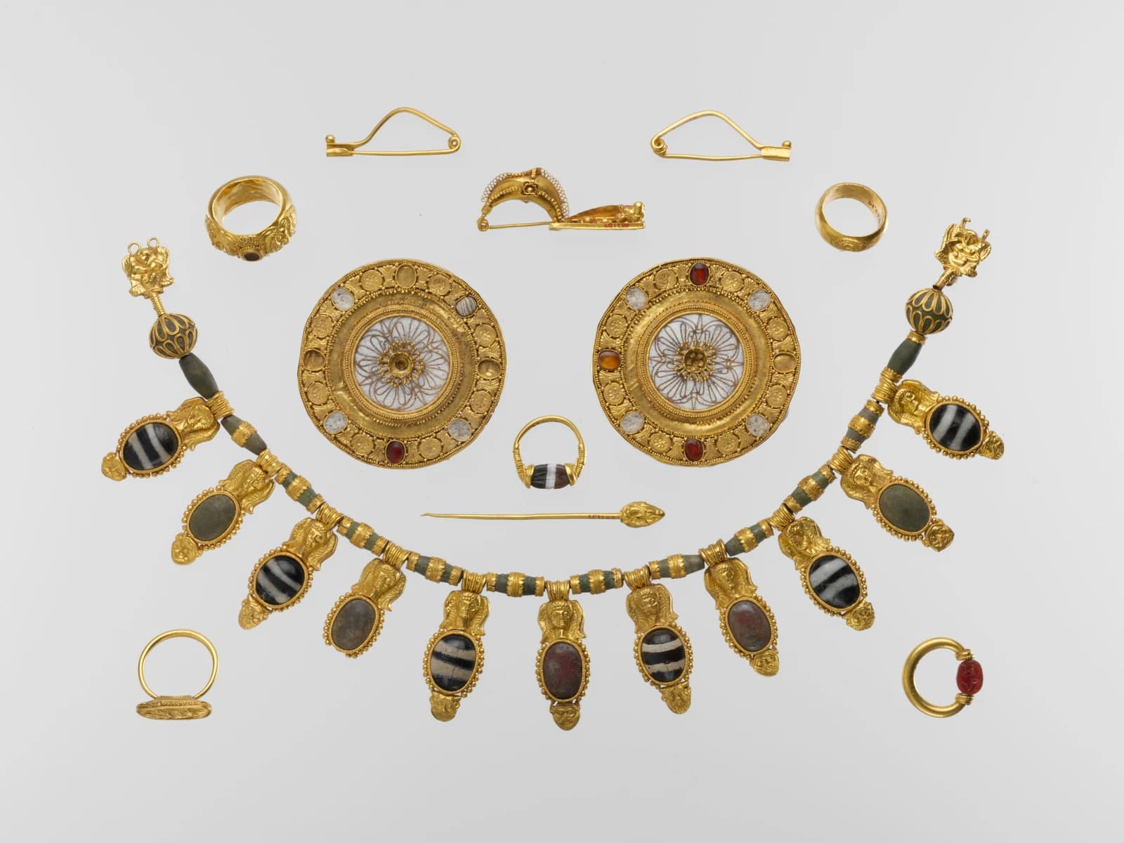 Set of gold jewelry, including a necklace, rings, and brooches.