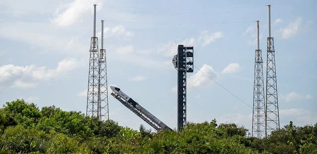 SpaceX Falcon 9 rocket with Dragon spacecraft at launch pad in Florida.