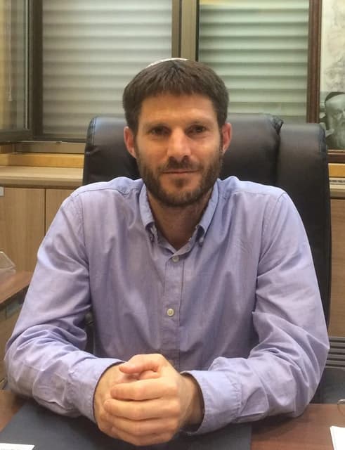 Bezalel Smotrich, Israeli politician, seated at a desk with his hands clasped.