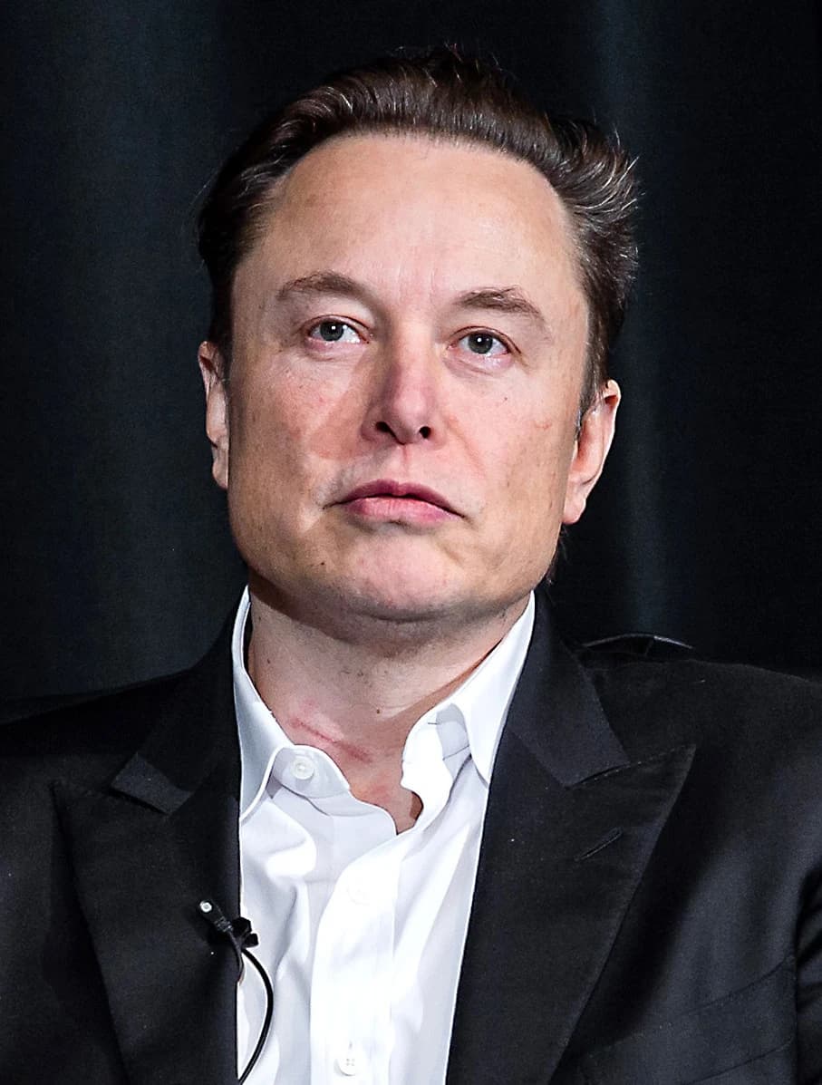Elon Musk, CEO of Tesla, sitting at an event in Colorado, looking forward.