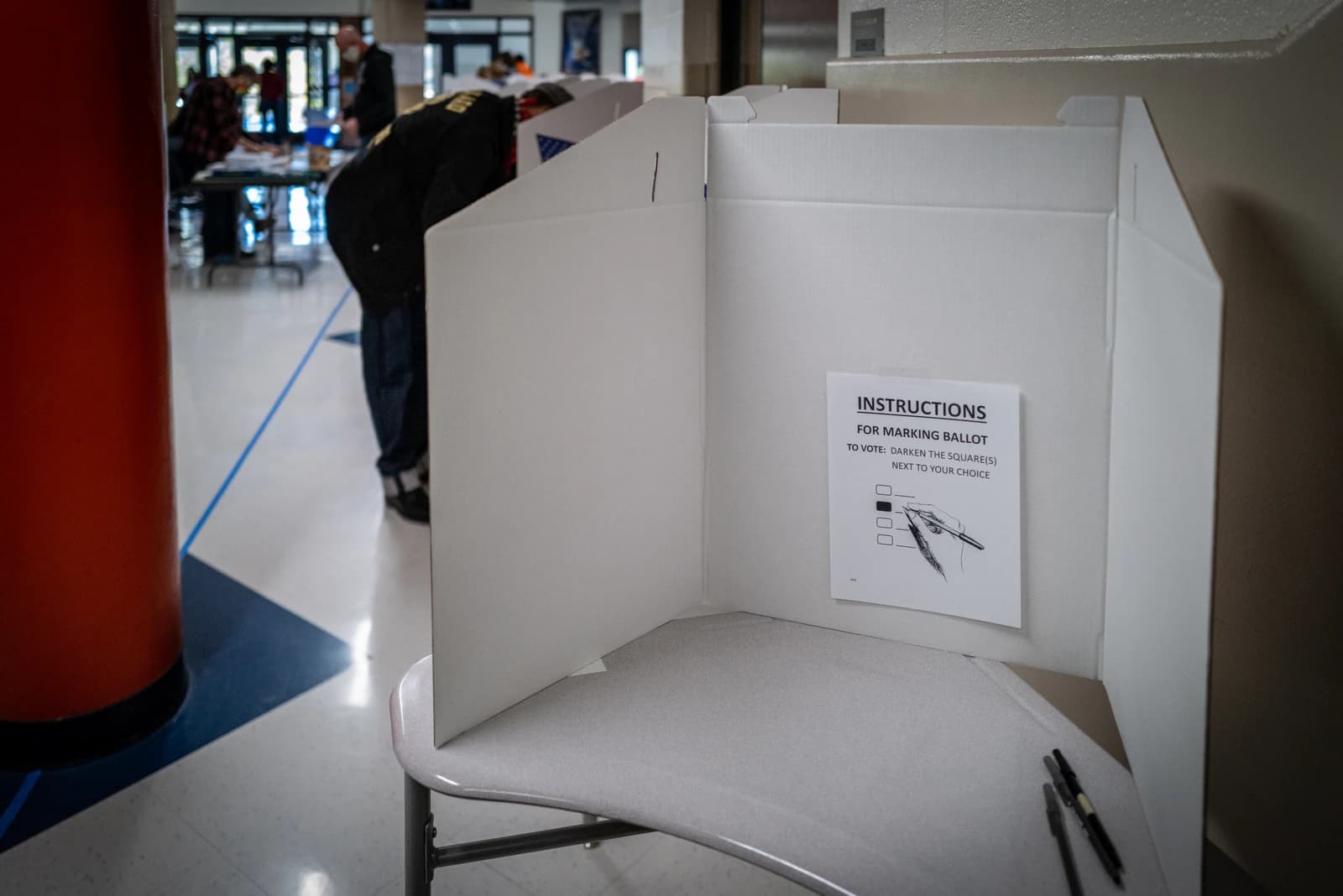 Voter at a polling station casts their ballot in a voting booth.