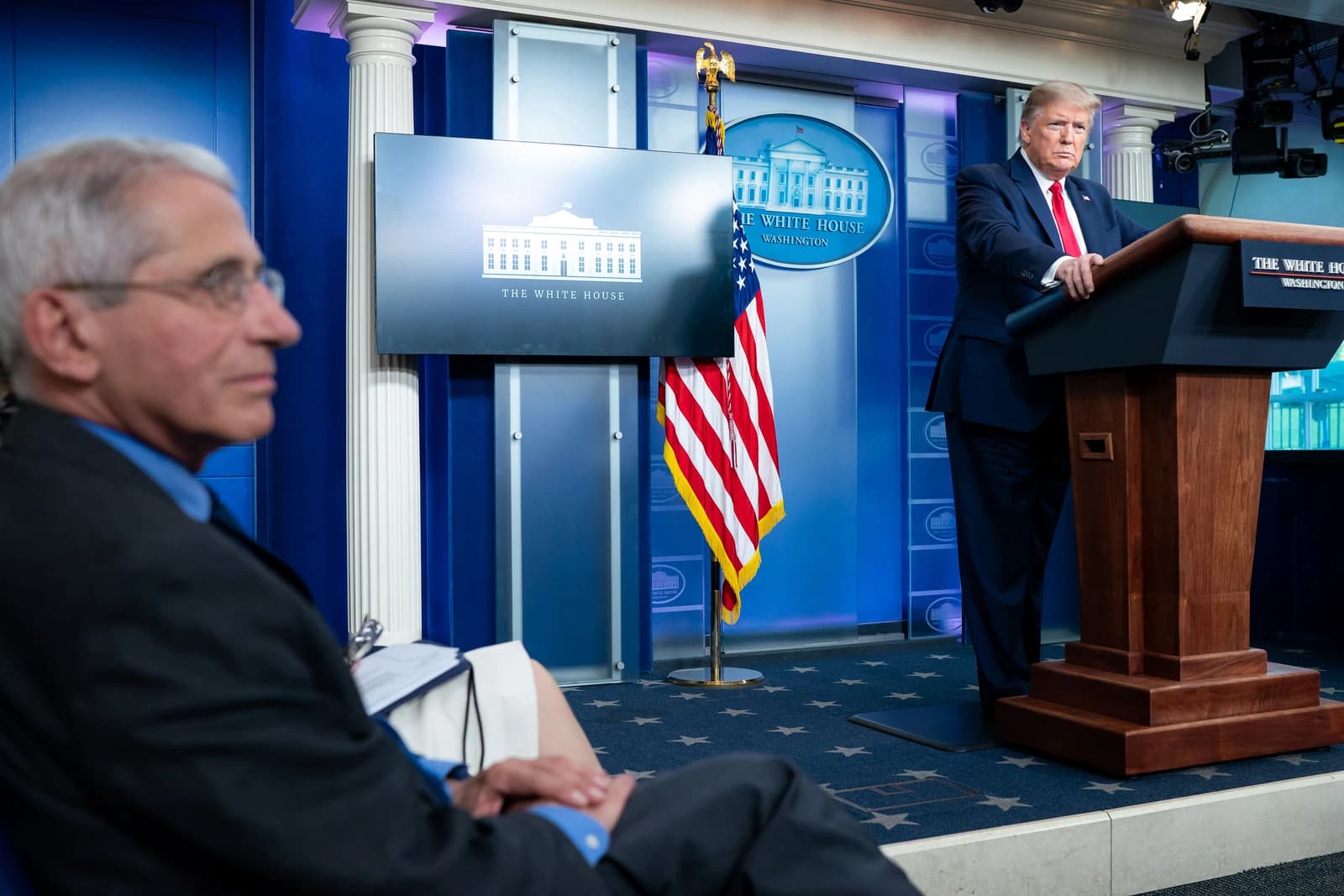 Donald Trump, President of the United States, stands at a podium at a White House briefing.