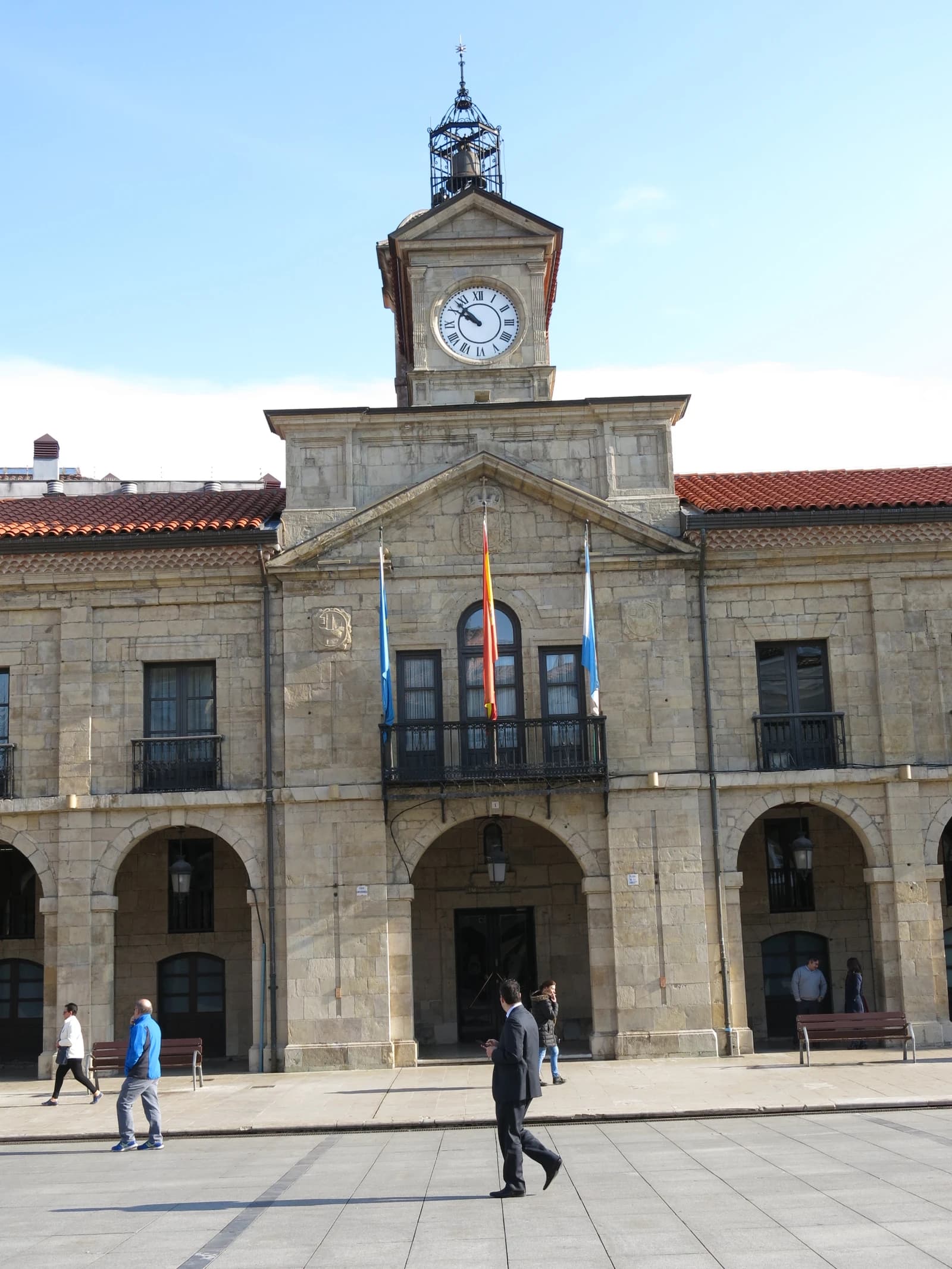 City Hall of Avilés, Spain, featuring a clock tower and flags on its facade.