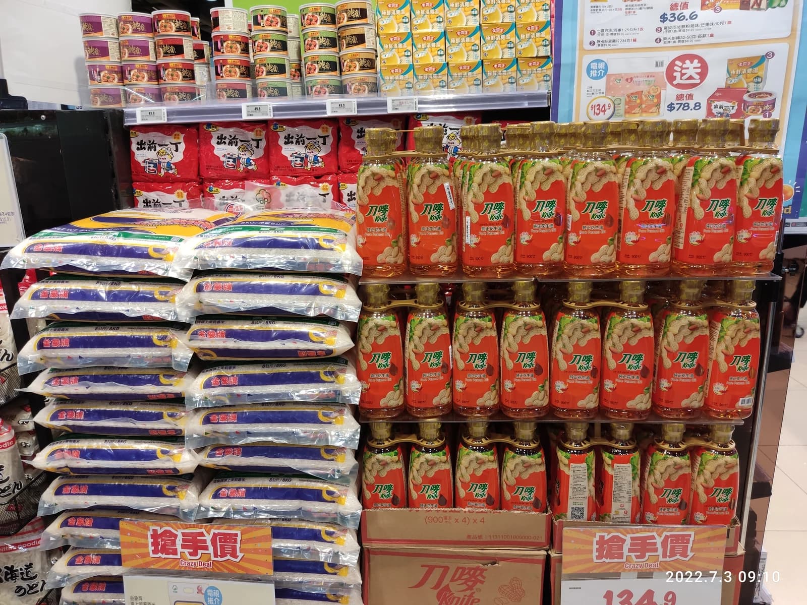 Cooking oil bottles and rice bags displayed on shelves in a Hong Kong supermarket.