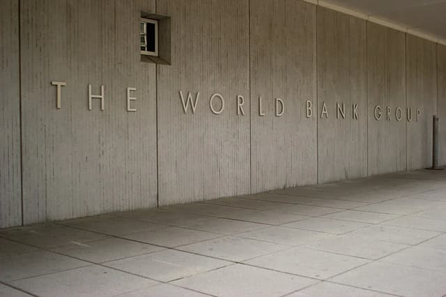 Exterior of The World Bank Group building with its name on a textured concrete wall.
