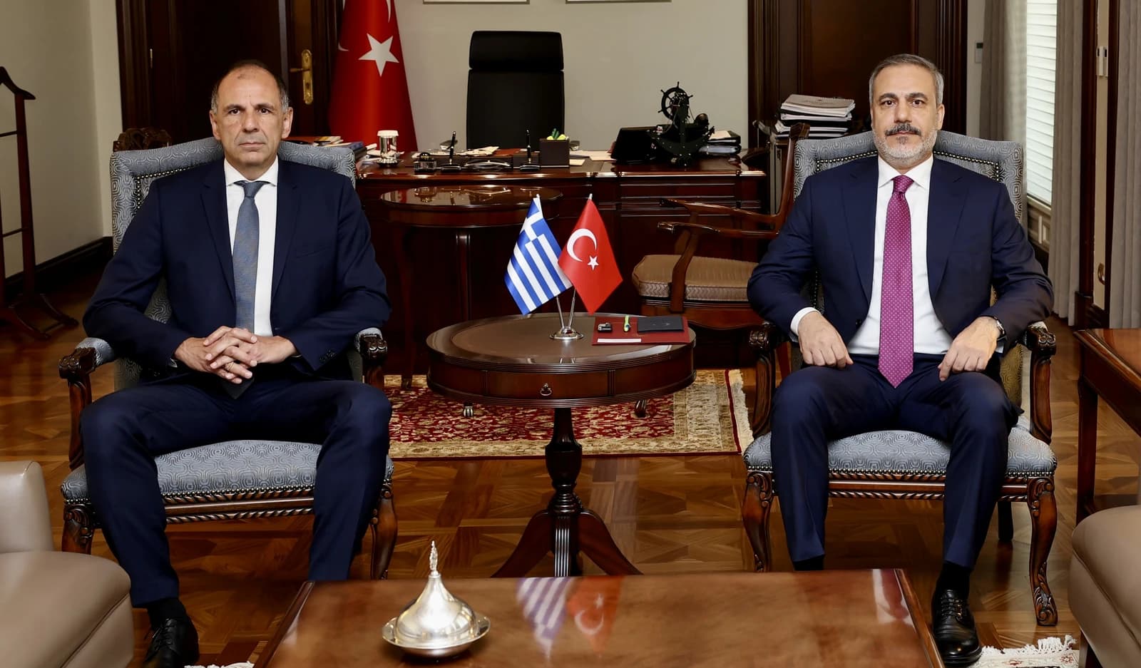 Greek Foreign Minister Giorgos Gerapetritis and Turkish Foreign Minister seated in an office.
