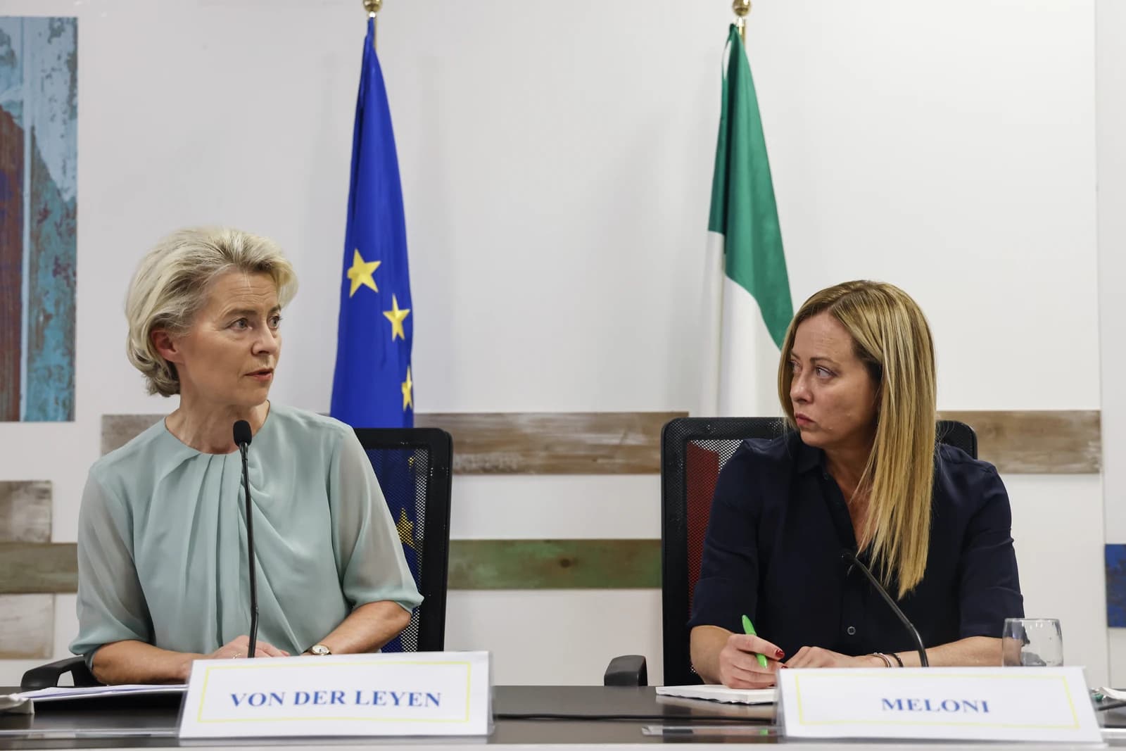Ursula von der Leyen and Giorgia Meloni sit at a table in Lampedusa, Italy.