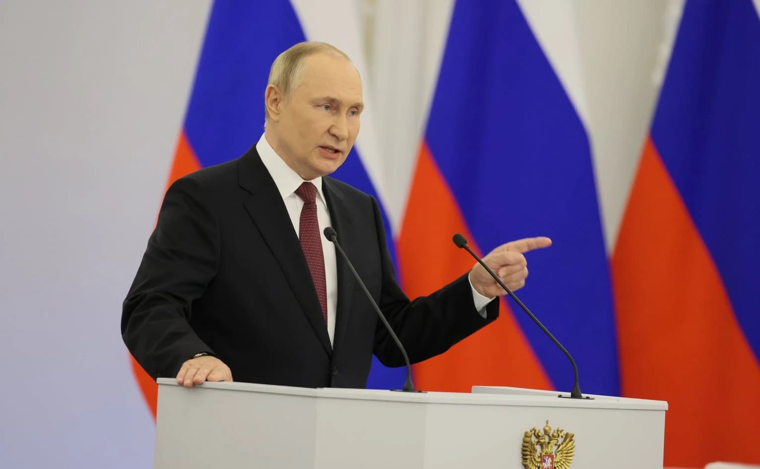 Vladimir Putin, President of Russia, speaking at a podium during a speech.