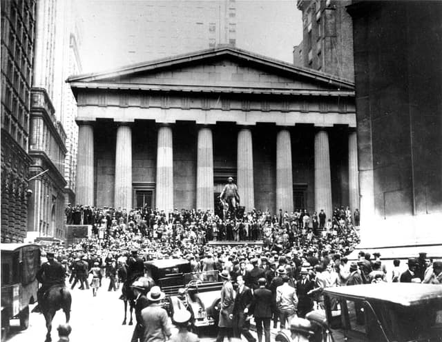 Crowds of people and vehicles gather outside the New York Stock Exchange building.