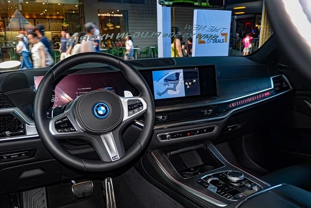 Interior of a BMW X5 PHEV M Sport Package, featuring the steering wheel and digital displays.