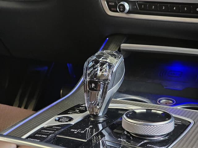 Interior of a BMW X5 featuring the crystal gear selector and driving mode buttons.