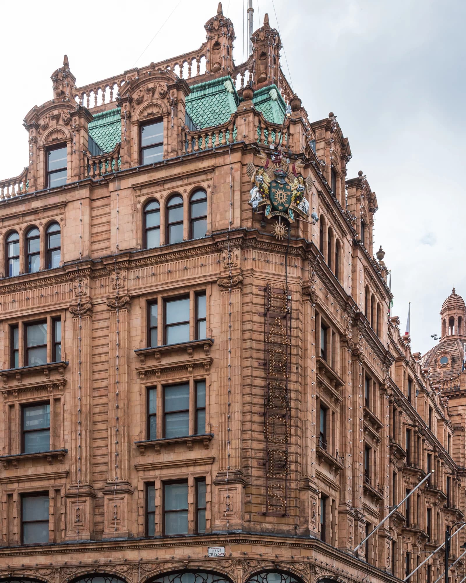 Exterior of Harrods department store in London, with ornate architectural details.