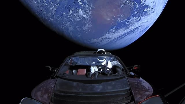 A Tesla Roadster with a dummy astronaut in the driver's seat, orbiting Earth in space.