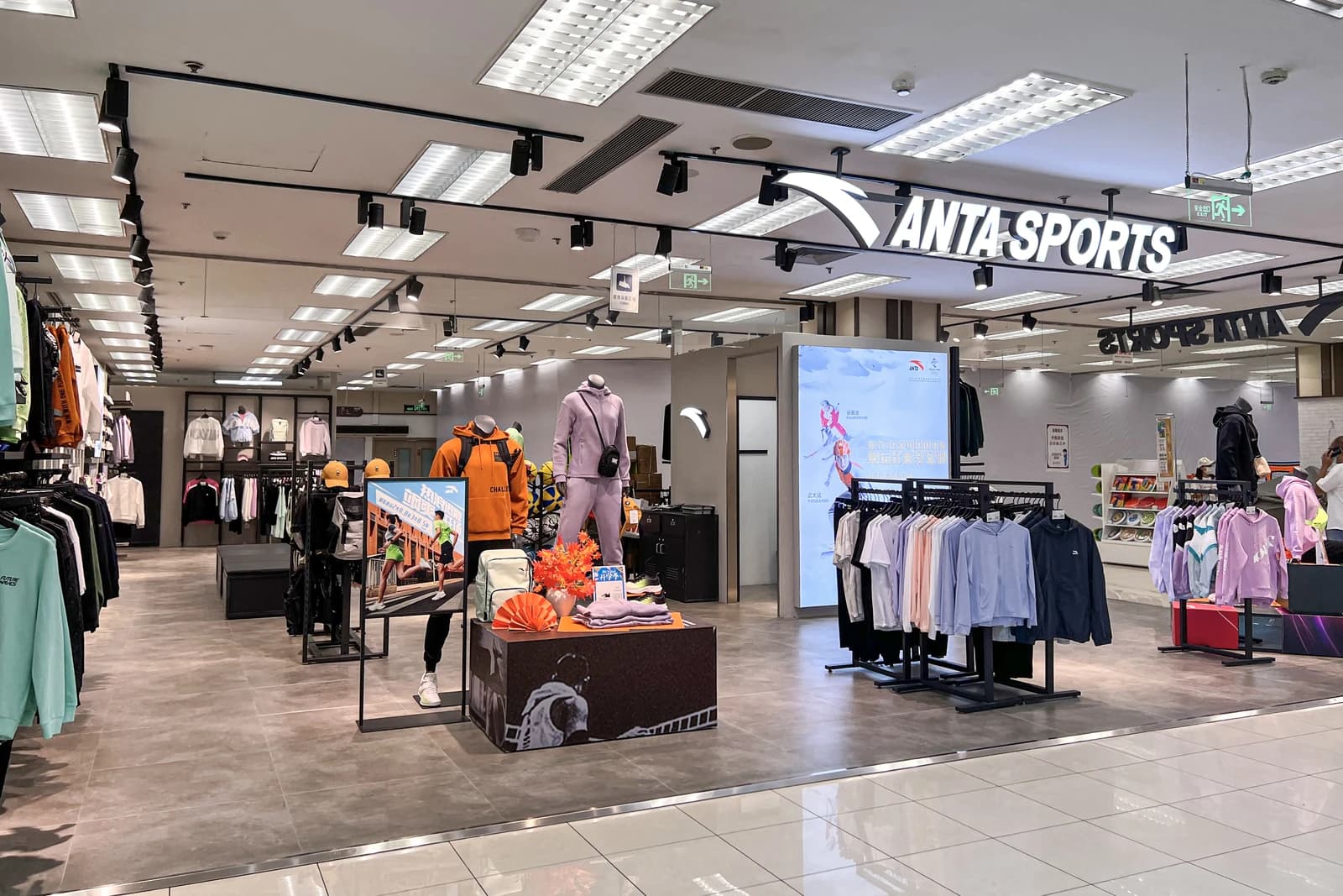 Interior view of an Anta Sports retail store with clothing displays and mannequins.