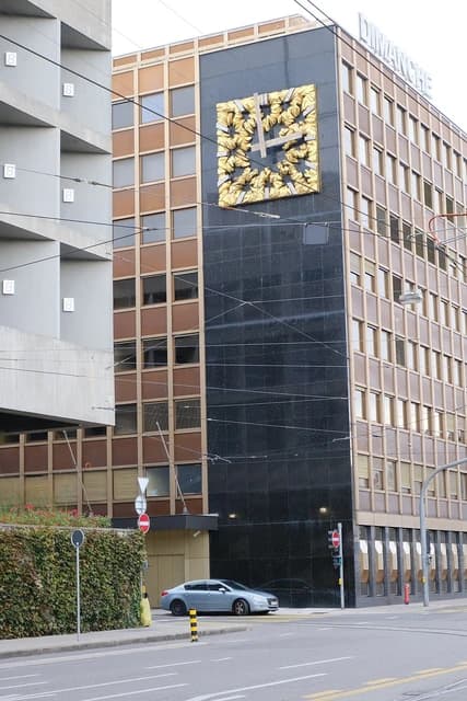 Exterior of Banque Lombard Odier & Cie building with a prominent golden clock on its facade.