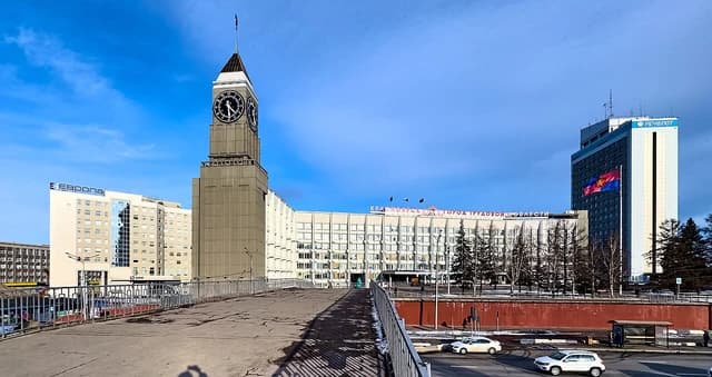 Krasnoyarsk City Hall building with a prominent clock tower and surrounding urban landscape.