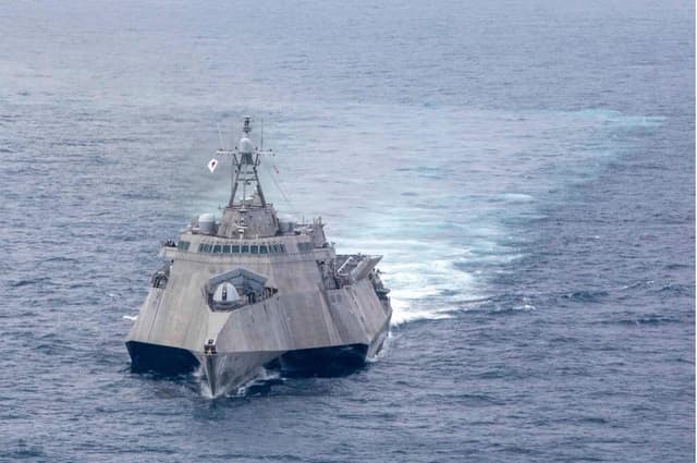 USS Charleston (LCS-18) sailing in the South China Sea, leaving a white wake.