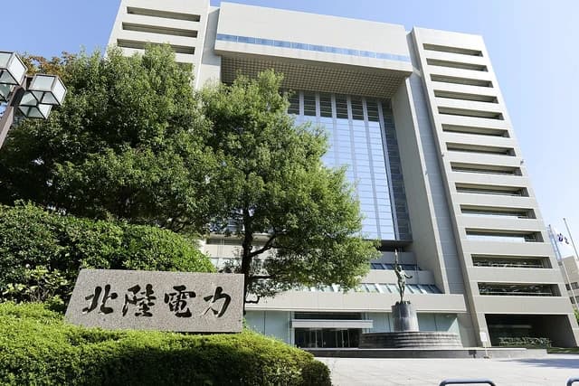 Hokuriku Electric Power Company building with its name on a stone sign.