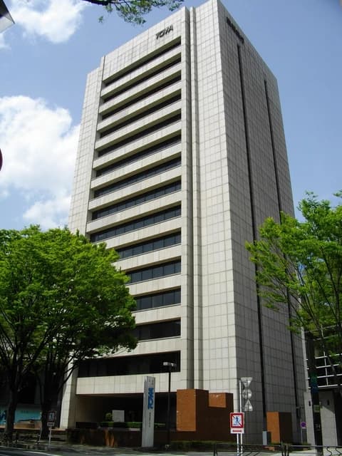 Towa Bank Head Office building exterior with trees and signage.