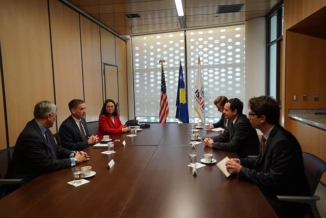 Albin Kurti, Kosovo Prime Minister, sits at a conference table with Mark Green and other officials.