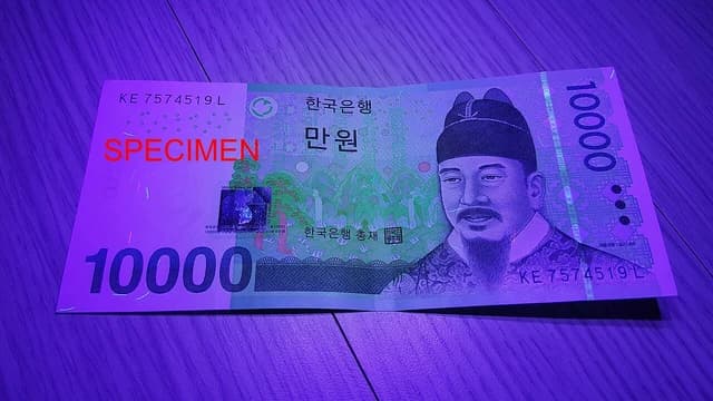 South Korean 10,000 won banknote with security features visible under ultraviolet light.
