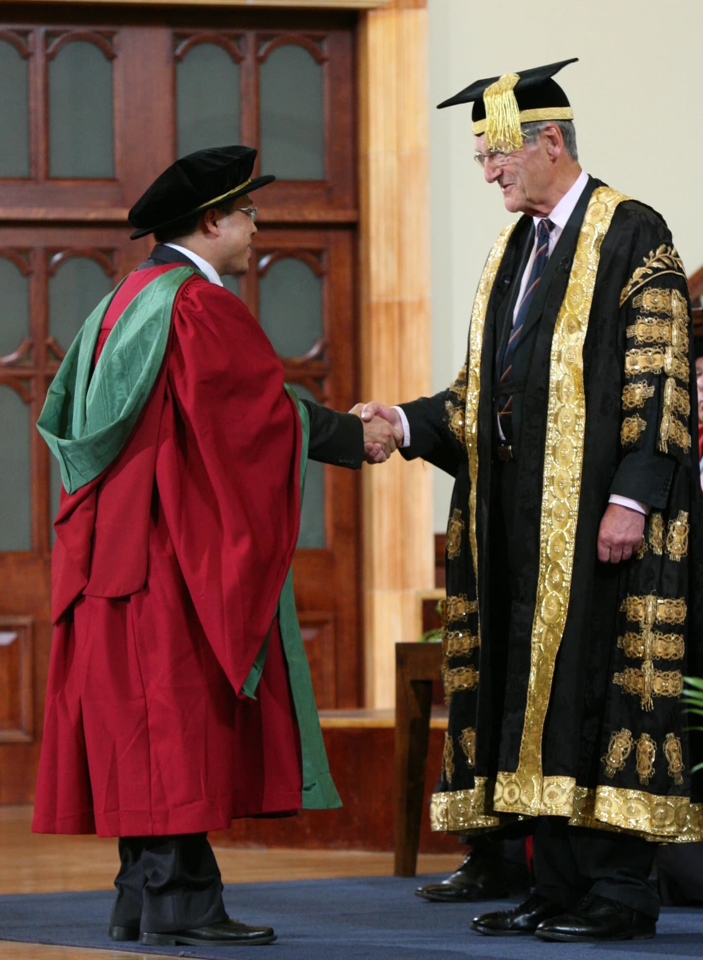 PhD graduand shaking hands with the Chancellor of the University.