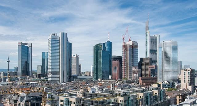 Skyscrapers in the financial district of Frankfurt, Germany, under a partly cloudy sky.