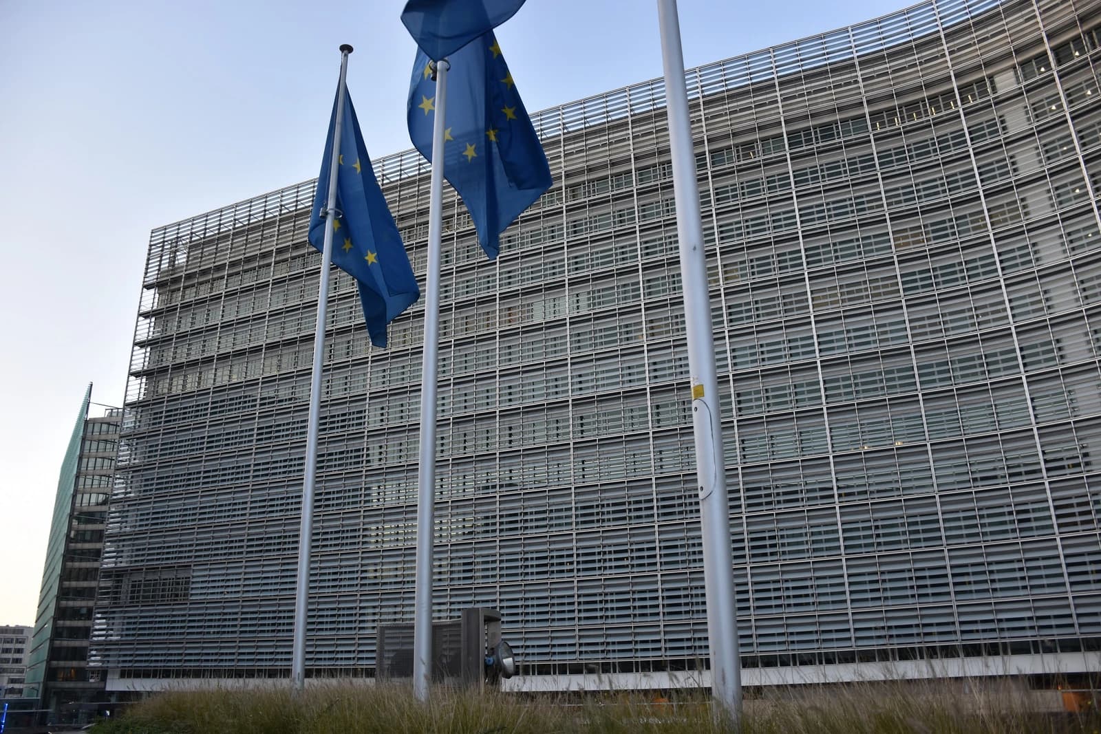 European Union flags flying outside the European Commission building in Brussels, Belgium.