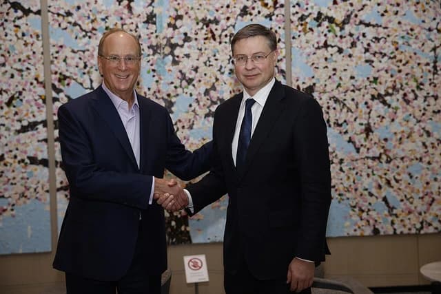 Larry Fink, CEO of BlackRock, shaking hands with Valdis Dombrovskis.