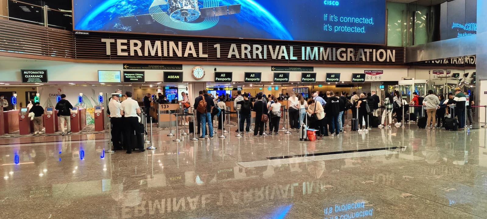 Travelers queue at the Terminal 1 Arrival Immigration area at Singapore Changi Airport.