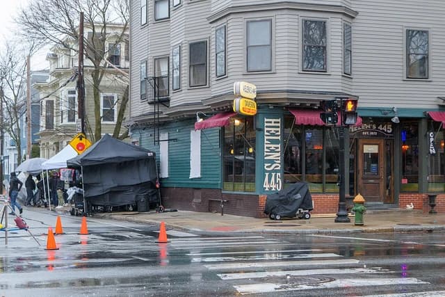 A street in front of Helen's 445 tavern with film equipment and crew members.
