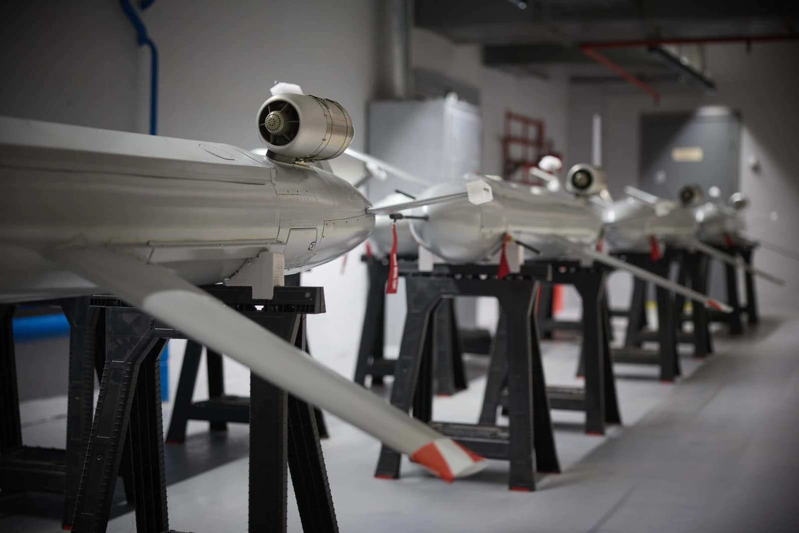 Several long-range weapons resembling drones on display in a production facility.