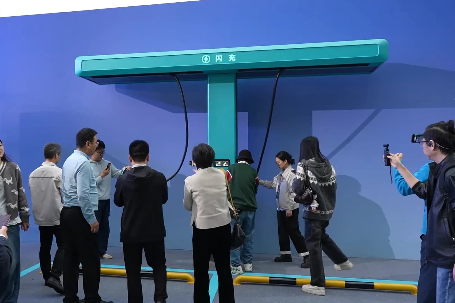 People observe a BYD Flash Charging 1500 kW charging station display.