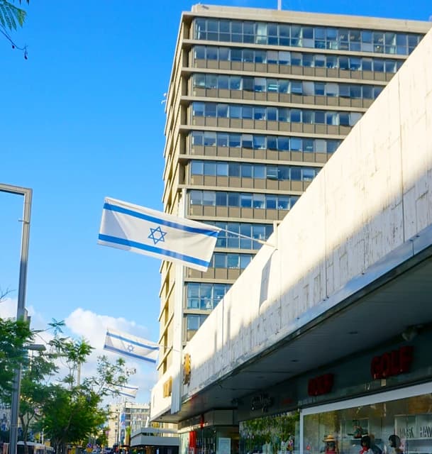 Israeli flags flying from a building in Tel Aviv.
