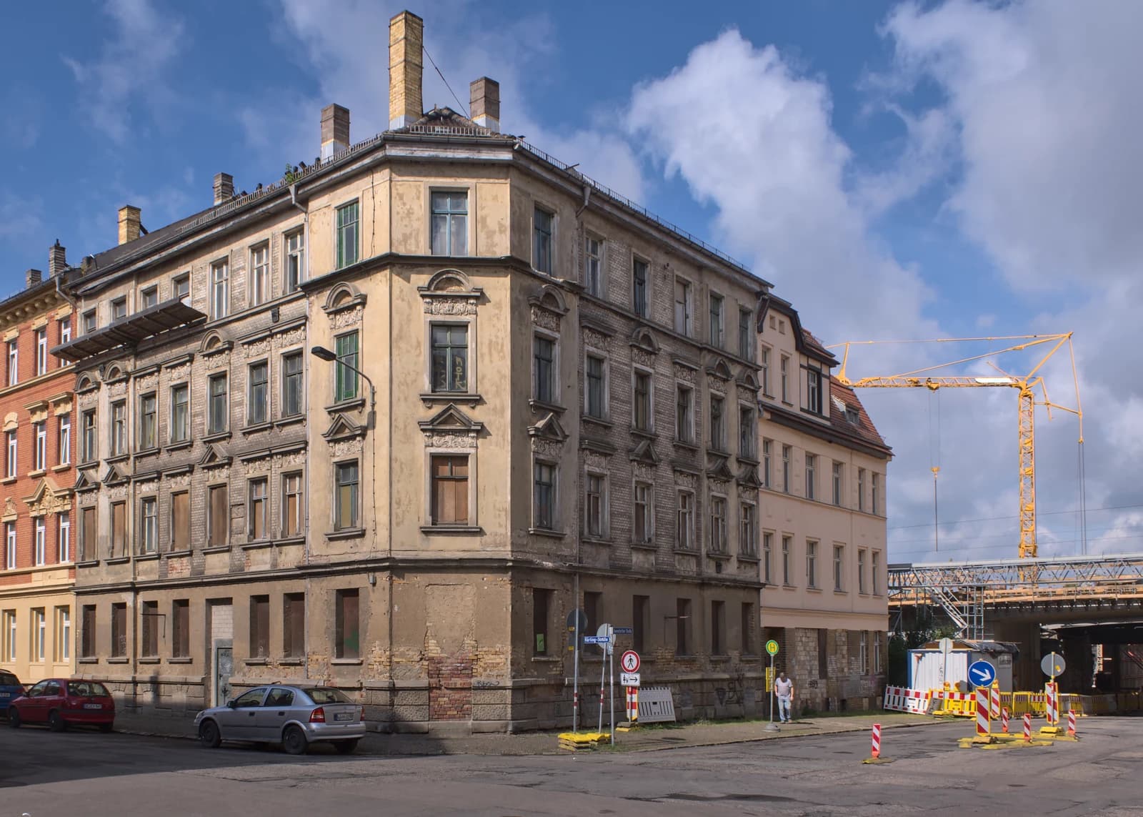 An old, multi-story apartment building with faded yellow walls and many windows.