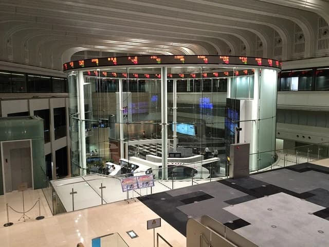Interior of the Tokyo Stock Exchange building showing trading screens and open floor plan.