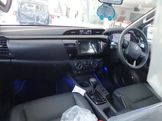 Interior of a 2019 Toyota Hilux Double Cab pickup truck, showing dashboard and steering wheel.